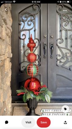 a vase filled with red and green balls sitting on top of a door sill