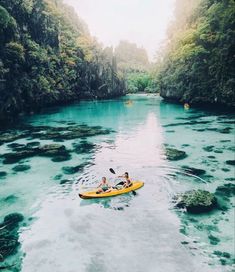 two people in a kayak paddling down a river