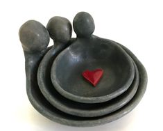 three gray bowls with red heart on top