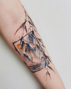 a watercolor tattoo on the arm of a woman