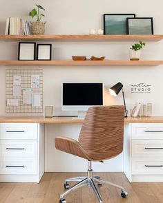 an office desk with a computer on top of it and shelves above the desk that hold books