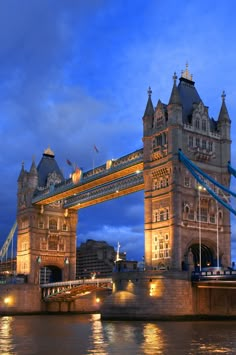 the tower bridge is lit up at night