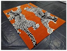 an orange rug with black and white cheetah print on the bottom, in front of a black background