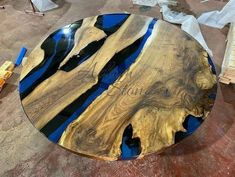 a table that has been made out of wood and blue glass in the center is being worked on