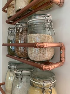 the shelves are filled with jars and other items to store for spices, nuts, grains, and more