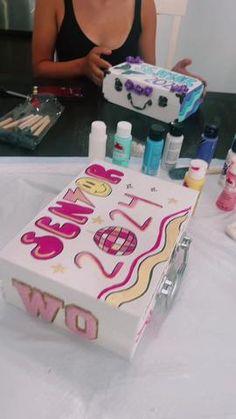 a woman sitting in front of a cake with the word love spelled out on it