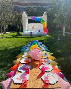 a long table set up with plates and balloons