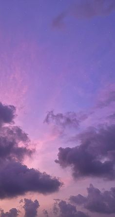 the sky is filled with purple clouds and stars