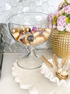 a vase filled with lots of gold and pink flowers on top of a white counter