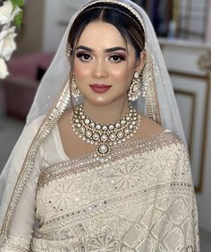 a woman wearing a bridal gown and jewelry