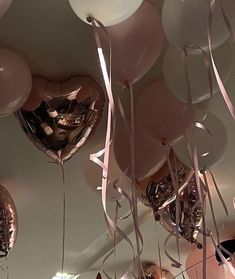 balloons and streamers hang from the ceiling in a room decorated with pink, white and gold