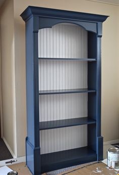 a blue bookcase sitting on top of a hard wood floor