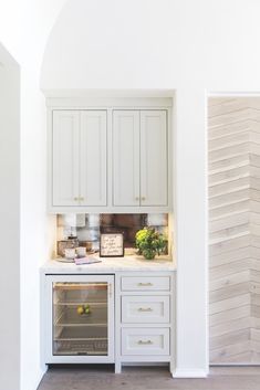 a kitchen with white cupboards and an oven in the center, along with other appliances