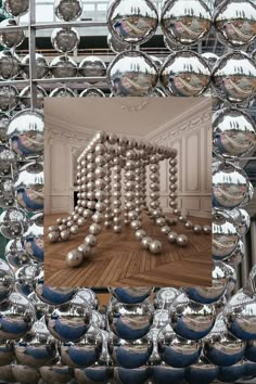 an image of a mirror with balls in the middle and a room full of mirrors behind it