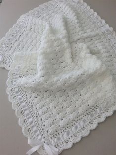 a white crocheted blanket on top of a table