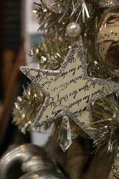 a christmas tree decorated with silver and white ornaments, including a star ornament