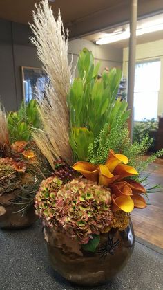 two vases filled with plants on top of a table