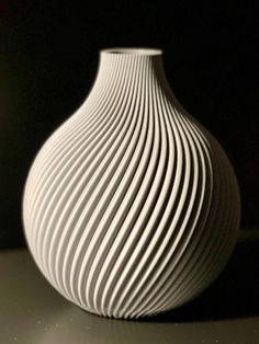 a white vase sitting on top of a table