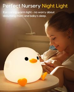 a woman laying in bed next to a night light that looks like a ducky