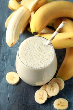 a smoothie in a glass surrounded by bananas