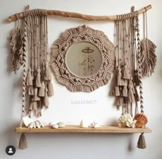 a mirror and shelf with tassels hanging from it's sides on the wall