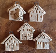 four clay houses are hanging on the table