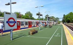 a train station with people waiting for the train