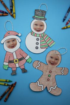 paper cutouts of two children and a snowman with crayons on the table