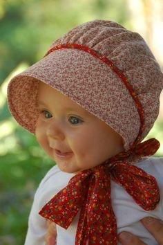 a baby wearing a red and white hat with a bow around it's neck