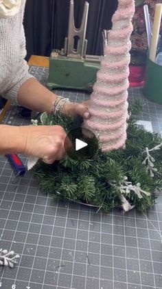 someone is making a wreath out of fake greenery