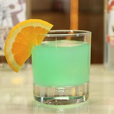 an orange slice sitting on top of a glass filled with liquid