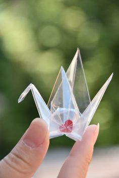 a person is holding a small origami bird