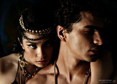 a man and woman are posing for a photo with their headpieces in the dark