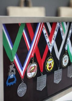 a group of medals hanging from the side of a metal frame on top of a counter