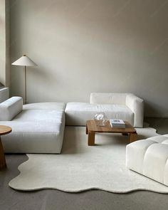 a living room with white couches and tables