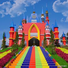 colorful stairs leading up to a castle like building with a clock on it's side