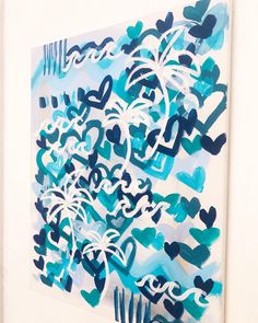 an abstract painting with blue and white paint on it's paper, hanging on a wall