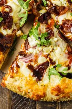 a close up of a pizza with toppings on a wooden table and one slice missing