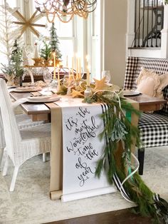 a dining room table decorated for christmas with greenery