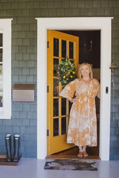 a woman standing in front of a yellow door