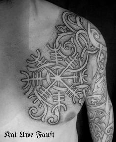 a man's chest with tattoos on it and an intricate design in the middle