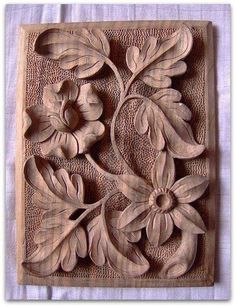 a carved wooden block with flowers and leaves