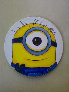 a painting of a minion with big eyes on a white plate that is sitting on a table