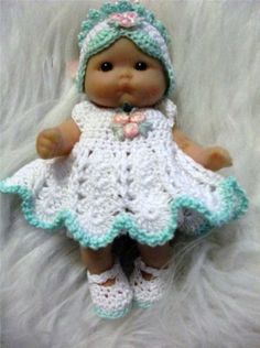 a baby doll wearing a crocheted dress and hat