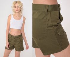 Vintage 70s Boy Scout shorts in olive green with patch pockets and a high waist. Please see measurements and condition below. Every garment we sell is authentic vintage! You will receive the exact item photographed. Condition: Very good vintage with light general wear. Best fits women's: Small. Boy's cut, so slim in the hip compared to the waist. Tag: ILGWU Material:  Feels like Cotton MEASUREMENTS Taken from seam to seam while the garment is lying flat. Double the armpit, waist, and hips For re Vintage Cotton Cargo Shorts With Pockets, Retro Khaki Bottoms With Pockets, High Waist Green Utility Shorts, Vintage Cotton Khaki Shorts, High-waist Green Shorts With Cargo Pockets, High-waisted Green Cargo Shorts, Green High-waisted Cargo Shorts, Vintage Cotton Shorts With Cargo Pockets, Military Style Summer Shorts With Belt Loops