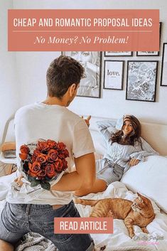 a man and woman sitting on a bed with a cat