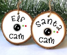 two wooden ornaments that say eff, santa's cam and eyeballs on them