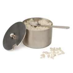 a metal container filled with rice next to a spoon