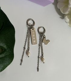 "Our HYYH Butterfly Earrings feature a butterfly charm on one side and a bar engraved with the Chinese idiom \"花樣年華\" used in BTS's The Most Beautiful Moment in Life album on the other.  These lightweight earrings are the perfect ARMY accessory. (If You Know, You Know)  Options include:  18k gold plated stainless steel with freshwater pearls.  platinum plated over stainless steel with freshwater pearls.  Longest chain measures around 3 inches in length." Chinese Idiom, Bts Jewelry, Army Accessories, Lightweight Earrings, Butterfly Charm, Butterfly Earrings, Light Weight Earrings, A Butterfly, Jewelry Earrings Hoops