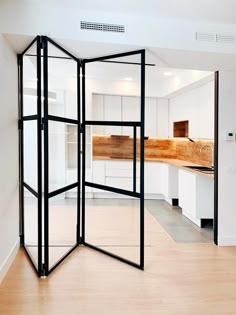 an open room divider sitting on top of a hard wood floor next to a kitchen